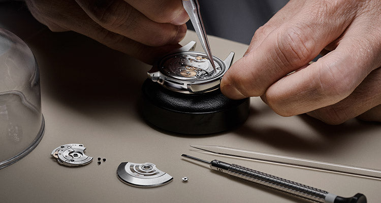 A watchmaker holding the watch and checking rolex for repair